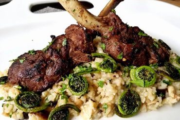 Frenched venison rack with mushroom risotto and sautéed fiddleheads