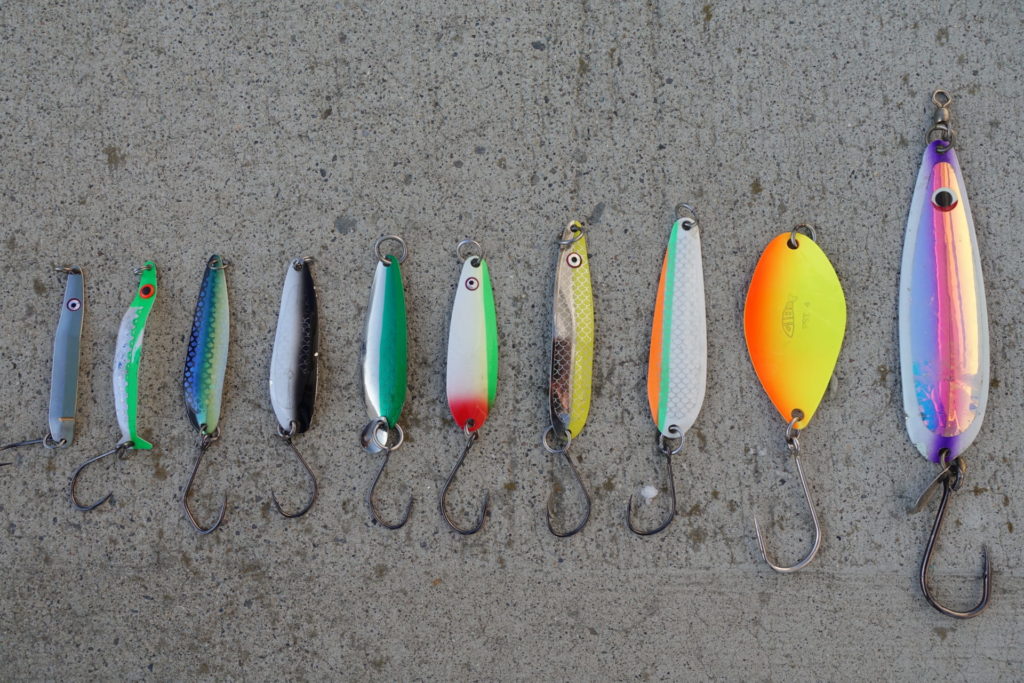 A good selection of trout spoons. From left to right, Wee-G in Gold Nugget, Coho Killer in Irish Cream, Kingfisher in Herring Aid, Gypsy in Paddy Wagon, Razorback in Killy Magee, G-Force in No Bananas, Skinny-G in Nickel Chartreuse, G-Force in Outfitter, FST in Fire Orange Chartreuse, Titan in Kinetic Purple.