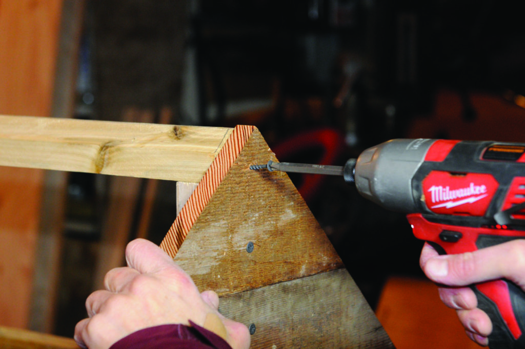 3B: Siding boards are screwed to the smokehouse frame.