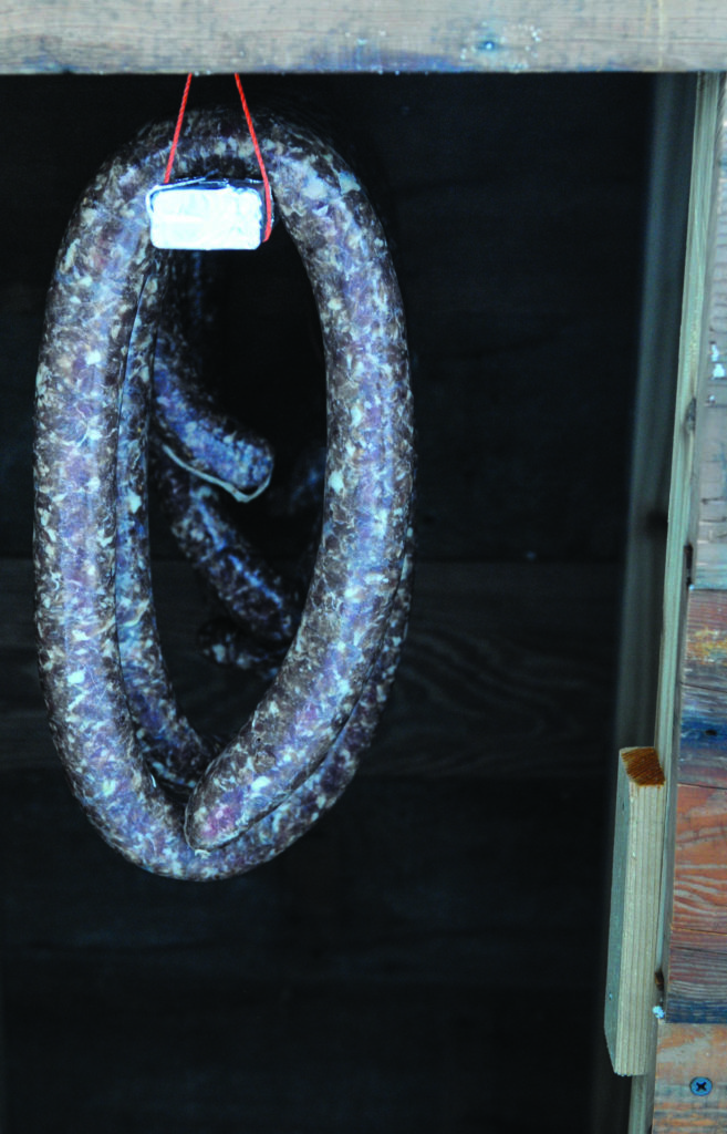 6: Fill your smokehouse with food. Pictured, the author is smoking fresh venison sausages using a DIY smokehouse. 