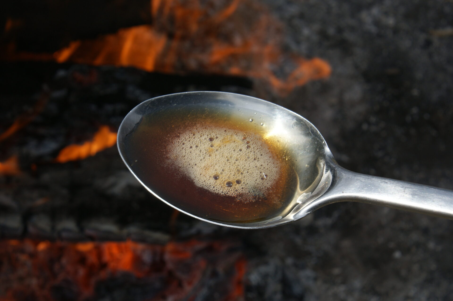 A spoonful of birch syrup boiling hot out of the pot.