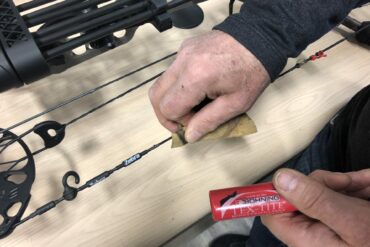 Use a small piece of leather or a leather glove to wax your strings.